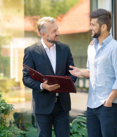 man woman talk man suit outside house
